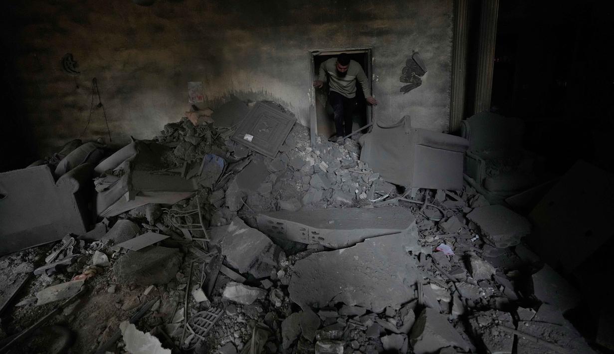 Seorang pria memeriksa kondisi apartemennya di lokasi bangunan yang hancur akibat serangan udara Israel di kota pelabuhan Tyre, Lebanon selatan, Kamis, 26 Maret 2026. Eskalasi serangan militer Israel ke Lebanon terus meningkat dalam beberapa hari terakhir. (AP Photo/Hussein Malla)