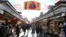 Pejalan kaki melintas di bawah dekorasi shio babi tanah yang mengarah ke kuil Buddha Asakusa Sensoji di Tokyo, Jepang, Kamis (27/12). Babi dipercaya memiliki sifatnya enerjik namun berhati-hati dalam mengambil keputusa. (AP Photo/Koji Sasahara)