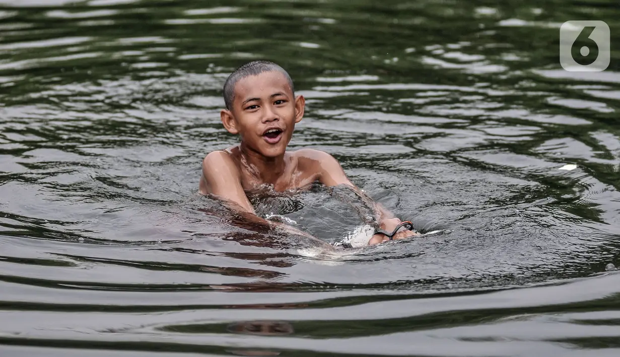 Seorang anak berenang di rawa pesisir Muara Baru, Cilincing, Jakarta, Minggu (15/8/2021). Anak-anak setempat memanfaatkan rawa sebagai wahana berenang akibat keterbatasan lahan bermain di wilayah pesisir tersebut. (merdeka.com/Iqbal S Nugroho)