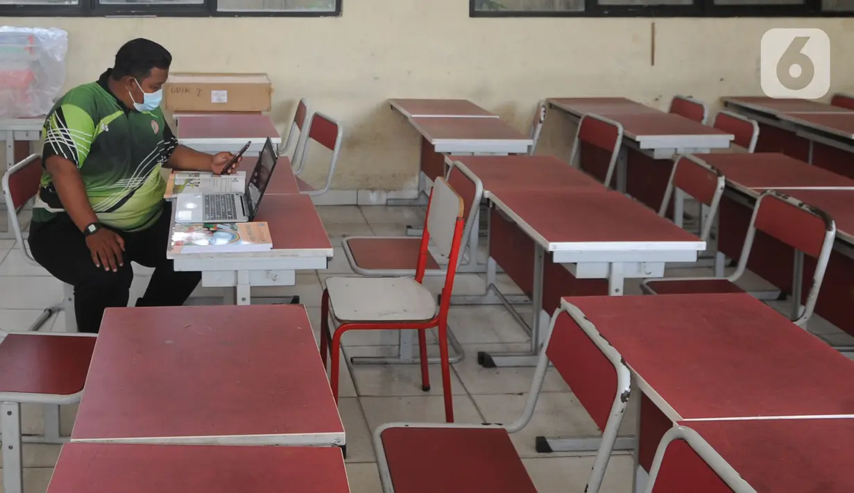 Guru mengajar mata pelajaran olah raga secara darling pada sebuah kelas kosong di SDN Pondok Cabe Udik 01, Pamulang, Tangerang Selatan, Jumat (8/1/2020). Berdasarkan SK Gubernur Banten terkait pembatalan kegiatan belajar tatap muka dikarenakan tingkat penularan covid-19 masih tinggi. (merdeka.com/Ar