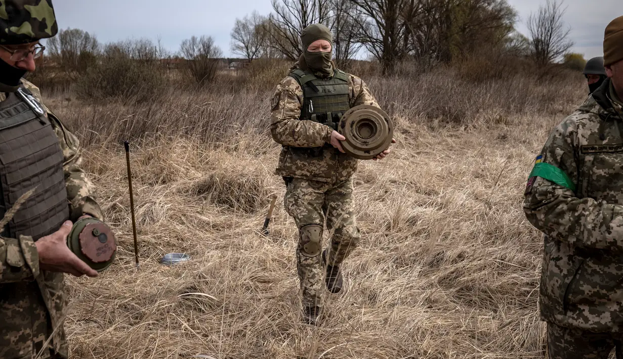 Anggota regu penjinak bom berjalan di ladang ranjau dekat Brovary, timur laut Kiev, di tengah invasi militer Rusia pada 14 April 202. Rusia sudah menarik tentara mereka dari Kiev dan mengalihkan sebagian besar fokus perangnya ke wilayah Ukraina timur pada akhir Maret. (FADEL SENNA/AFP)