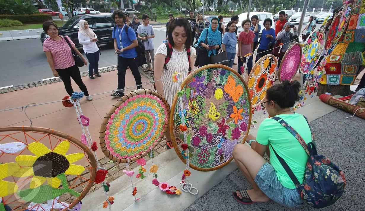 Warga menikmati Taman Pandang Istana yang baru diresmikan di depan Istana Negara, Jakarta, Sabtu (30/7). Taman tersebut guna tempat bersantai bagi masyarakat. (Liputan6.com/Immanuel Antonius)