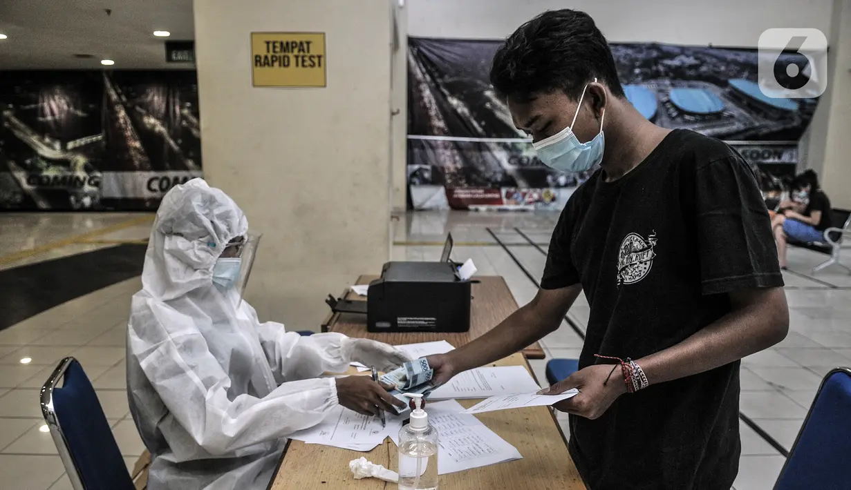 Calon penumpang bus antarkota antarprovinsi (AKAP) membayar rapid test antigen COVID-19 di Terminal Pulogebang, Jakarta, Rabu (30/12/2020). Layanan ini dibanderol dengan harga Rp 150 ribu per orang. (merdeka.com/Iqbal S. Nugroho)