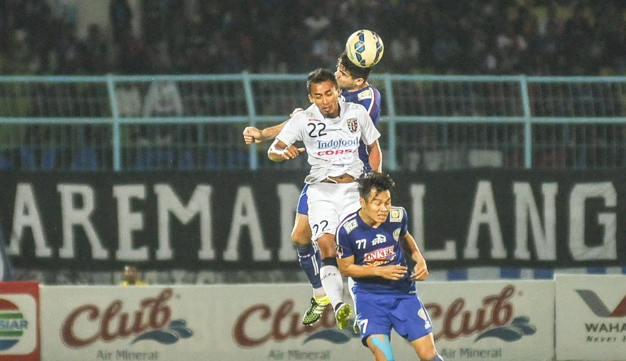 Pemain Bali United, Sultan Samma melakukan duel udara dengan pemain Arema Cronus pada laga perempat final Piala Presiden di Stadion Kanjuruhan, Malang, Sabtu (19/9/2015). (Bola.com/Kevin Setiawan))