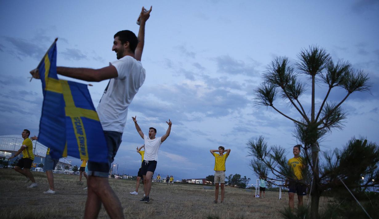 Sejumlah suporter Swedia berpesta di sekitar Pantai Sochi, Jumat (22/6/2018). Para suporter bersiap untuk menyaksikan laga Piala Dunia 2018 antara Swedia melawan Jerman. (AFP/Rebecca Blackwell)