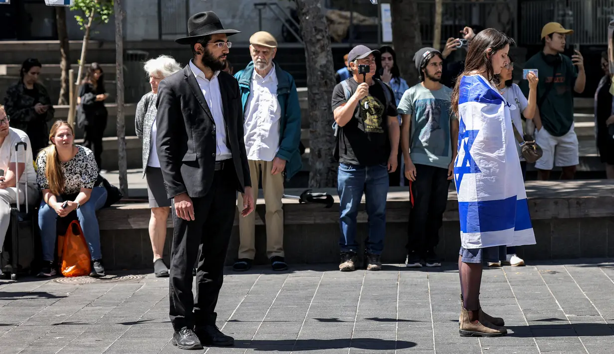 Orang-orang berhenti dan berdiri dalam keheningan selama dua menit pada Hari Peringatan tentara yang gugur (Yom HaZikaron) di Yerusalem pada 25 April 2023. (AFP/RONALDO SCHEMIDT)