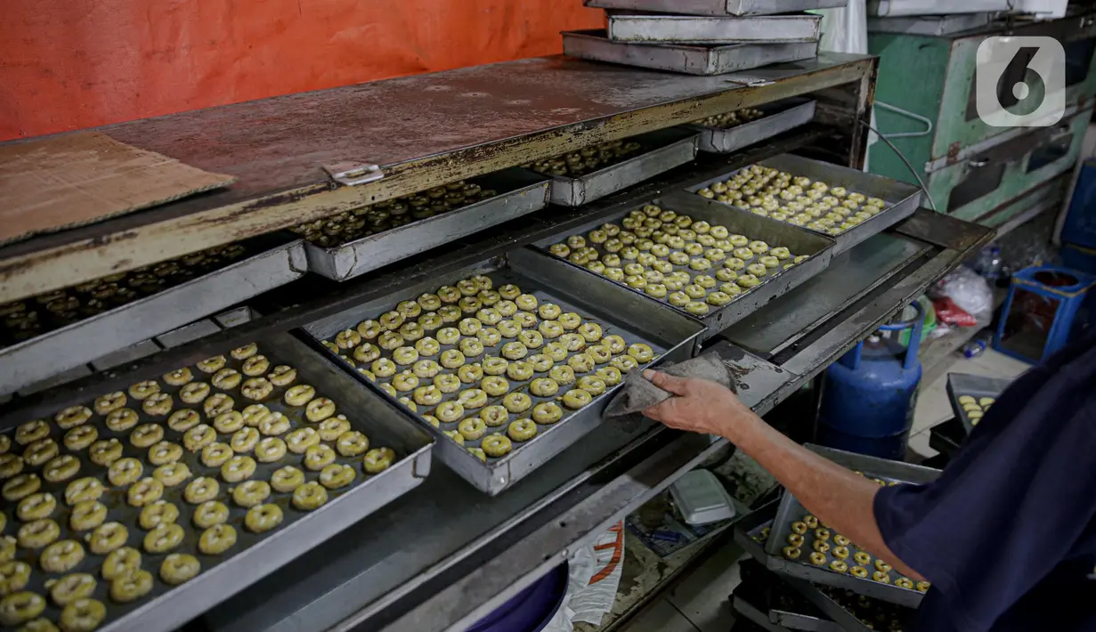 Pekerja menyelesaikan pembuatan kue kering di industri rumahan di Kawasan Kwitang, Jakarta, Jumat (30/4/2021). Tahun ini produksi kue kering menjelang lebaran mulai meningkat namun masih mengalami penurunan produksi hingga separuhnya dibandingkan dengan sebelum pandemi. (Liputan6.com/Faizal Fanani)