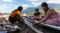 Nelayan perempuan membersihkan ikan di atas perahu di Danau Nam Ngum di Provinsi Vientiane, Laos, pada 15 Desember 2020. Terletak di hilir Sungai Nam Ngum dan sekitar 80 km dari ibu kota, Danau Nam Ngum merupakan tempat dengan ratusan pulau kecil yang tersebar di dalamnya. (Xinhua/Kaikeo Saiyasane)
