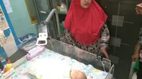 Ari-ari bayi berselimut merah muda itu masih menempel di badan. (Liputan6.com/Fajar Eko Nugroho)