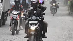 Pengendara melintasi jalan yang dipenuhi debu tebal di Jalan Kemukus, Tamansari, Jakarta Barat, Senin (24/11/2014). (Liputan6.com/Faizal Fanani)