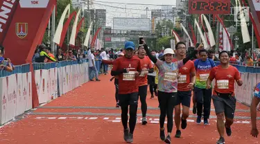 Pelari tiba di garis finish saat mengikuti Semarang 10K di Kota Semarang, Jawa Tengah, Minggu (16/12). Sebanyak 2.000 pelari mengikuti Semarang 10K. (Liputan6.com/Gholib)