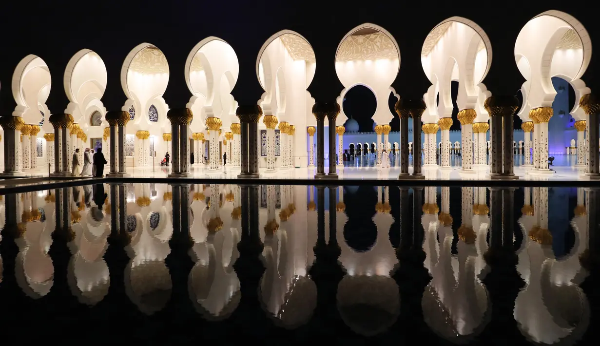 Pengunjung berjalan di lorong Masjid Agung Sheikh Zayed ketika persiapan salat tarawih pertama di Abu Dhabi, Rabu (17/5). Masjid ini dibangun oleh presiden pertama Uni Emirat Arab, yaitu Sheikh Zayed bin Sultan Al Nahyan. (AFP PHOTO/KARIM SAHIB)