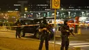 Pasukan bersenjata berjaga di area Bandara Internasional Schiphol, Amsterdam, Belanda, yang ditutup menyusul ancaman bom, Selasa (12/4).  Pihak kepolisian menangkap seorang pria dengan perilaku mencurigakan terkait ancaman bom. (Michel van Bergen/ANP/AFP)