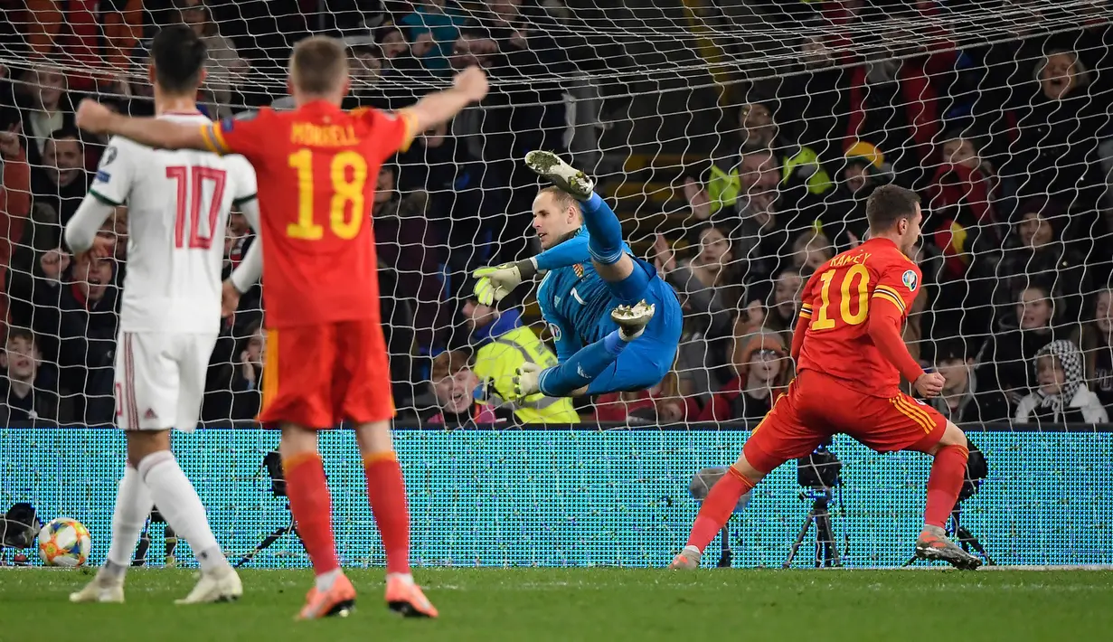 Gelandang Timnas Wales, Aaron Ramsey merayakan gol yang dicetaknya ke gawang Hungaria pada laga Grup E Kualifikasi Piala Eropa 2020 di Cardiff City Stadium, Selasa (19/11/2019). Ramsey jadi pahlawan usai dua golnya memastikan satu tempat untuk Wales di putaran final. (Tamas Kovacs/MTI via AP)