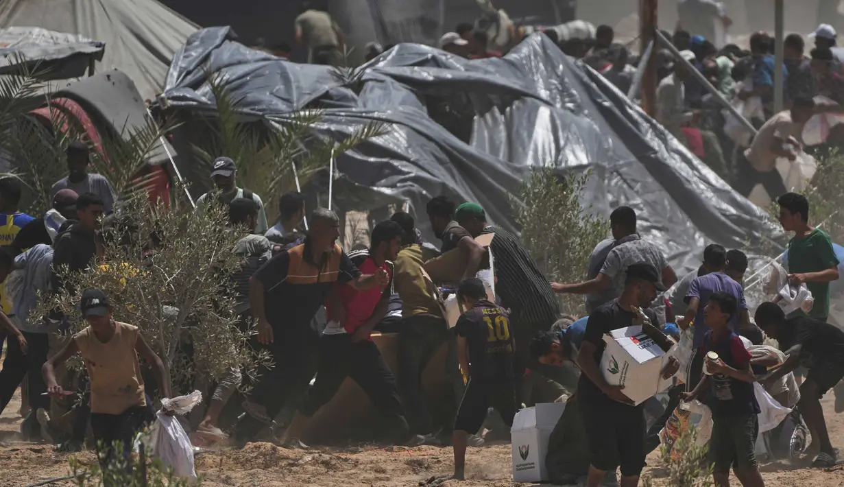 Warga Palestina berbondong-bondong mengumpulkan paket bantuan kemanusiaan dari Uni Emirat Arab yang dijatuhkan dengan parasut ke Deir al-Balah, bagian tengah Jalur Gaza, pada Selasa 19 Agustus 2025. (AP Photo/Abdel Kareem Hana)