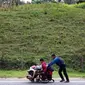 Migran Venezuela, Jefferson Alexis mendorong kursi roda ayahnya, Jose Agustin Lopez di Norte de Santander Department, Kolombia, 15 September 2018. Mereka harus menempuh 600 km dari Venezuela ke Bogota untuk mendapatkan pengobatan. (AFP/SCHNEYDER MENDOZA)