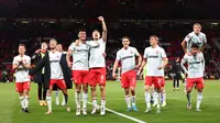 Para pemain FC Twente, termasuk Mees Hilgers, menghampiri fans di tribune setelah laga melawan MU di Old Trafford pada lanjutan Europa League atau Liga Europa, Kamis (26/9/2024) dini hari WIB. (Darren Staples / AFP)