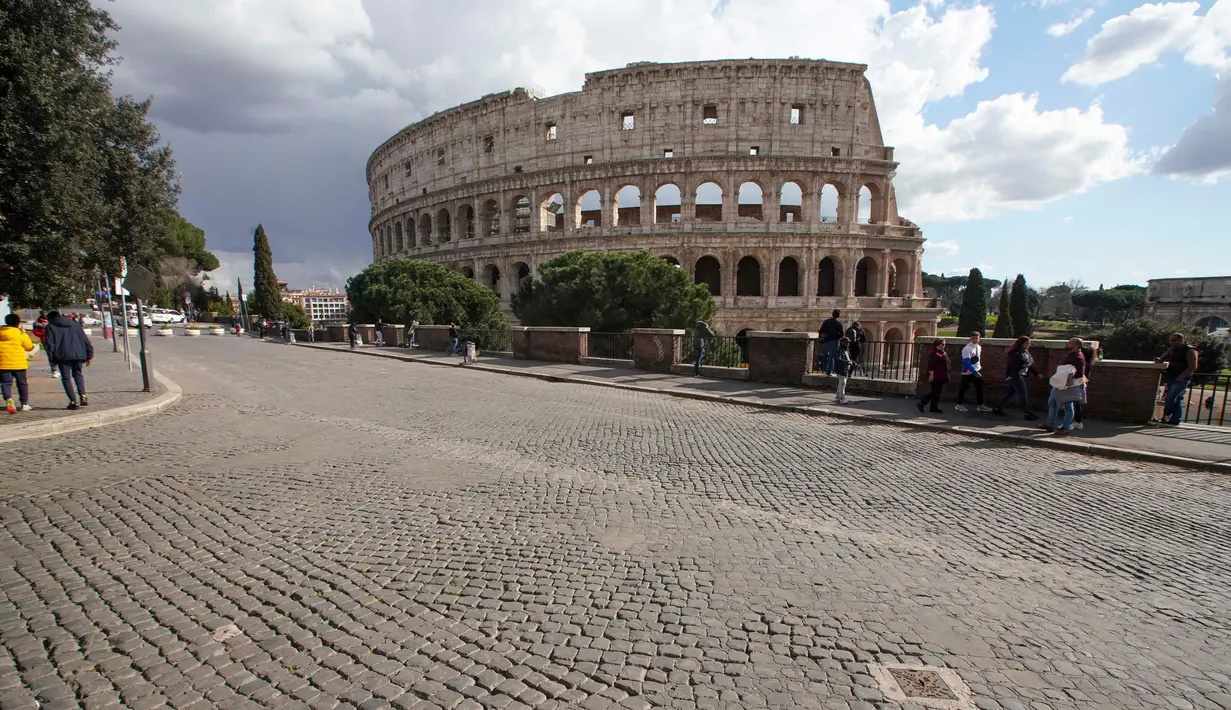 Sejumlah orang berada di kawasan Colosseum di Roma, Sabtu (7/3/2020). Kekhwatiran terhadap virus corona (COVID-19) membuat tempat-tempat pariwisata di Italia sepi pengunjung, seperti di kawasan Colosseum yang merupakan salah satu dari keajaiban dunia. (AP Photo/Andrew Medichini)