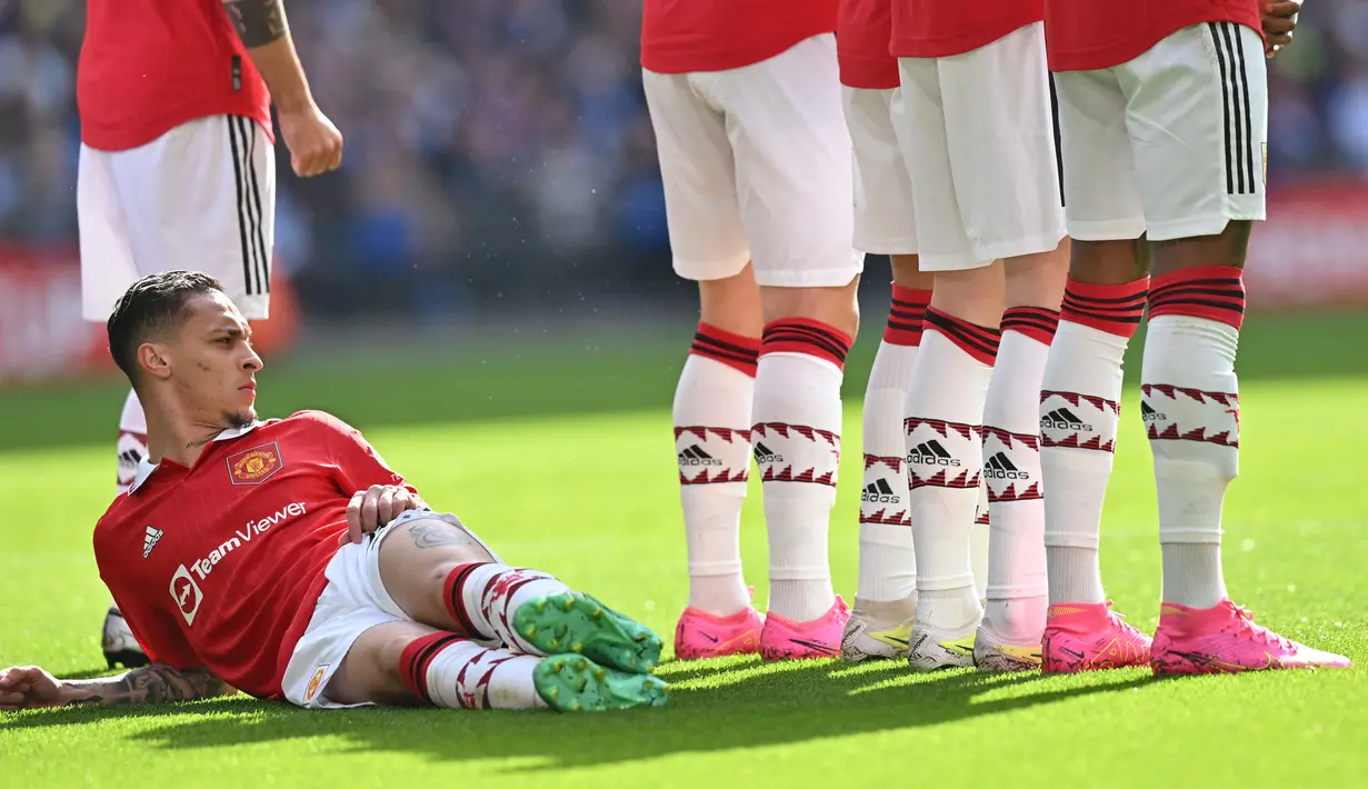 Gelandang Manchester United, Antony berbaring di belakang rekan-rekannya saat terjadi tendangan bebas saat menghadapi Brighton and Hove Albion pada laga semifinal Piala FA 2022/2023 di Wembley Stadium, London (23/4/2023). Antony didatangkan Manchester United dari Ajax Amsterdam pada awal musim 2022/2023 dengan nilai transfer 95 juta euro atau setara Rp1,5 triliun dengan durasi kontrak selama 5 tahun. Dari 25 penampilan di Liga Inggris, ia hanya mencetak 4 gol dan 2 assist. (AFP/Glyn Kirk)