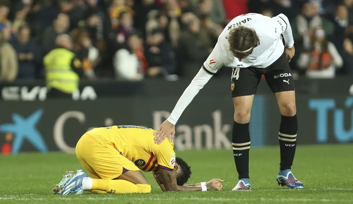 Bek Valencia Yarek Gasiorowski menghibur penyerang Barcelona Raphinha setelah laga pekan ke-17 La Liga 2023/2024 di Stadion Mestalla, Minggu (17/12/2023) dini hari WIB. (AP Photo/Alberto Saiz)
