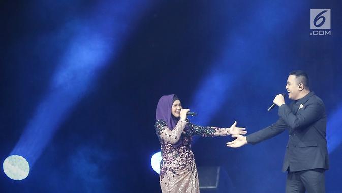 Penyanyi Siti Nurhaliza (kiri) berduet dengan Tulus dalam konser 'Dato Sri Siti Nurhaliza on Tour' di Istora Senayan, Jakarta, Kamis (21/2). Siti mengaku gugup saat berduet dengan Tulus. (Fimela.com/Bambang E Ros)