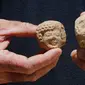 Seorang arkeolog menunjukkan pecahan keramik berupa stempel bertuliskan huruf Ibrani kuno yang ditemukan di sebuah situs penggalian di Yerusalem (22/7/2020). Tim arkeolog Israel menemukan pusat penyimpanan administratif berusia 2.700 tahun di Yerusalem. (Xinhua/Gil Cohen Magen)