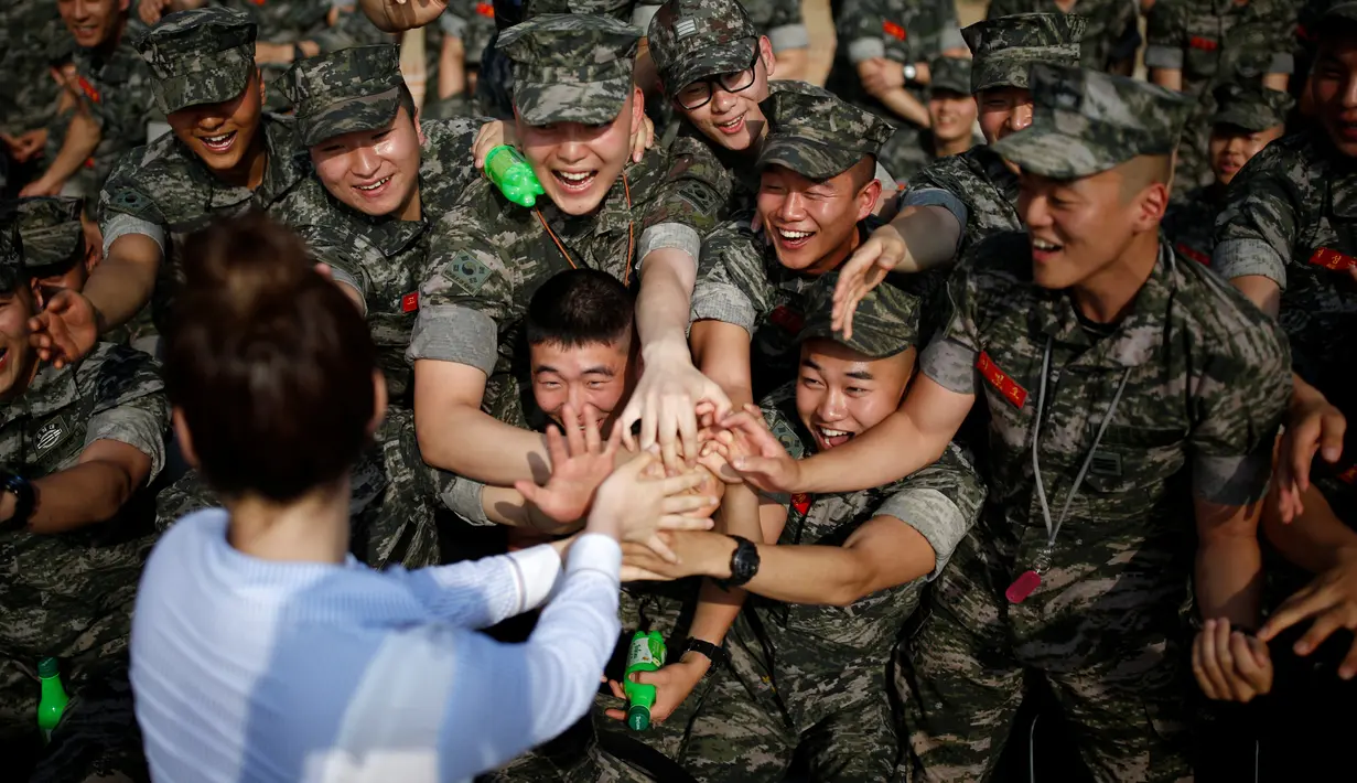 Sejumlah tentara saat berebutan bersalaman dengan penyanyi Kpop yang menghibur mereka di pangkalan laut dekat zona demiliterisasi yang memisahkan Korea Selatan dan Korea Utara, Gimpo, Korea Selatan, 10 Juni 2016. (REUTERS / Kim Hong - Ji)