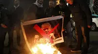 Demonstran Palestina membakar gambar Presiden AS Donald Trump di alun-alun Betlehem, 5 Desember 2017. (AFP)