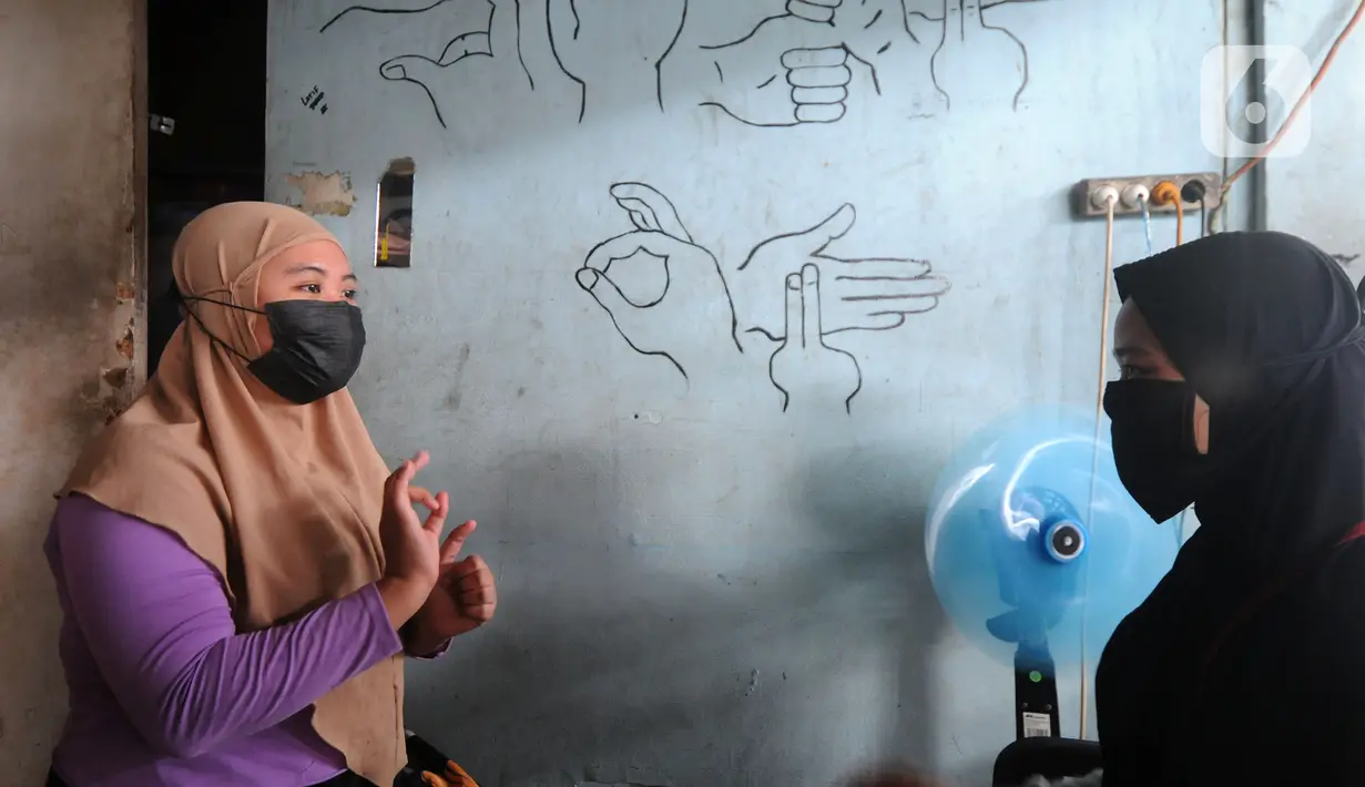 Karyawan penyandang tunarungu berkomunikasi menggunakan bahasa isyarat di Deaf Cafe and Car Wash di kawasan Cinere, Depok, Jawa Barat, Senin (27/9/2021). Seluruh karyawan di tempat ini melayani pelanggannya dengan bahasa isyarat untuk memberdayakan penyandang tunarungu. (merdeka.com/Arie Basuki)