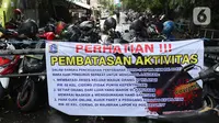 Spanduk tentang pembatasan aktivitas terpampang di pintu masuk perumahan di kawasan Cideng, Jakarta, Kamis (2/4/2020). Pemerintah menetapkan Pembatasan Sosial Berskala Besar dengan membatasi kegiatan tertentu penduduk di wilayah yang diduga terinfeksi COVID-19. (Liputan6.com/Helmi Fithriansyah)