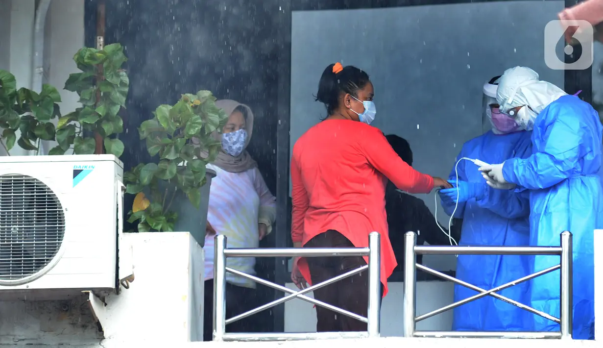 Tim paramedis dari Sudinkes Jakarta Selatan melakukan pemeriksaan kesehatan berkala kepada pasien Covid-19 yang berstatus sebagai OTG di Graha Wisata Ragunan, Senin (14/12/2020). Sebanyak 13 pasien OTG Covid-19 saat ini menjalani isolasi mandiri di Graha Wisata Ragunan. (merdeka.com/Arie Basuki)