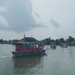 Sejumlah perahu yang membawa puluhan umat Buddha beserta  kota berisi ikan saat melaju ke tengah Danau Sipin Jambi, Selasa (26/5/2021). Puluhan umat Buddha di Jambi menggelar ritual Fangsheng dengan melepasliarkan ikan ke danau. (Liputan6.com/Gresi Plasmanto)