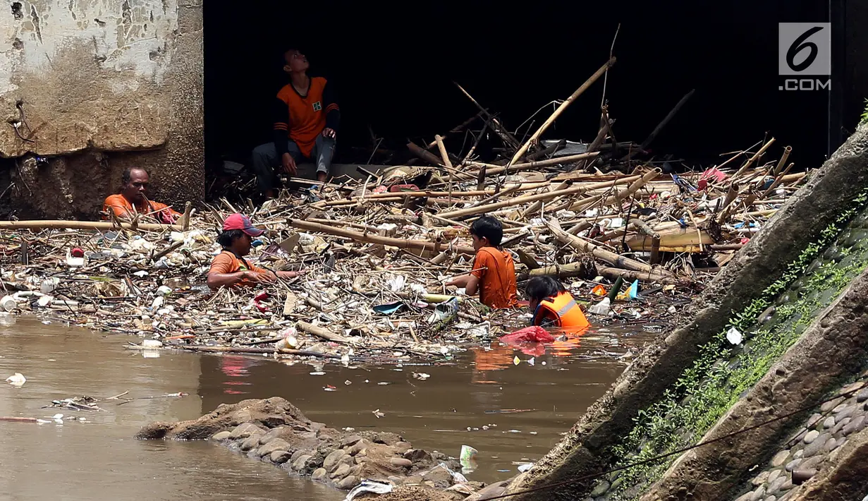 Pasukan Orange mengangkat sampah yang terbawa arus sungai di Pintu air Manggarai, Jakarta, Senin (2/10). Pembersihan itu dilakukan untuk melancarkan aliran Sungai Ciliwung yang melewati Pintu Air Manggarai (Liputan6.com/Johan Tallo)