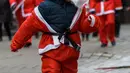 Seorang anak mengenakan kostum Sinterklas ikut serta dalam kegiatan amal Santa's Fun Run di Riga, Latvia, Minggu (8/12/2019). Ini merupakan acara amal yang pesertanya bersenang-senang dengan berlari atau berjalan kaki untuk mengumpulkan dana bagi anak-anak di rumah sakit Latvia. (Gints Ivuskans/AFP)