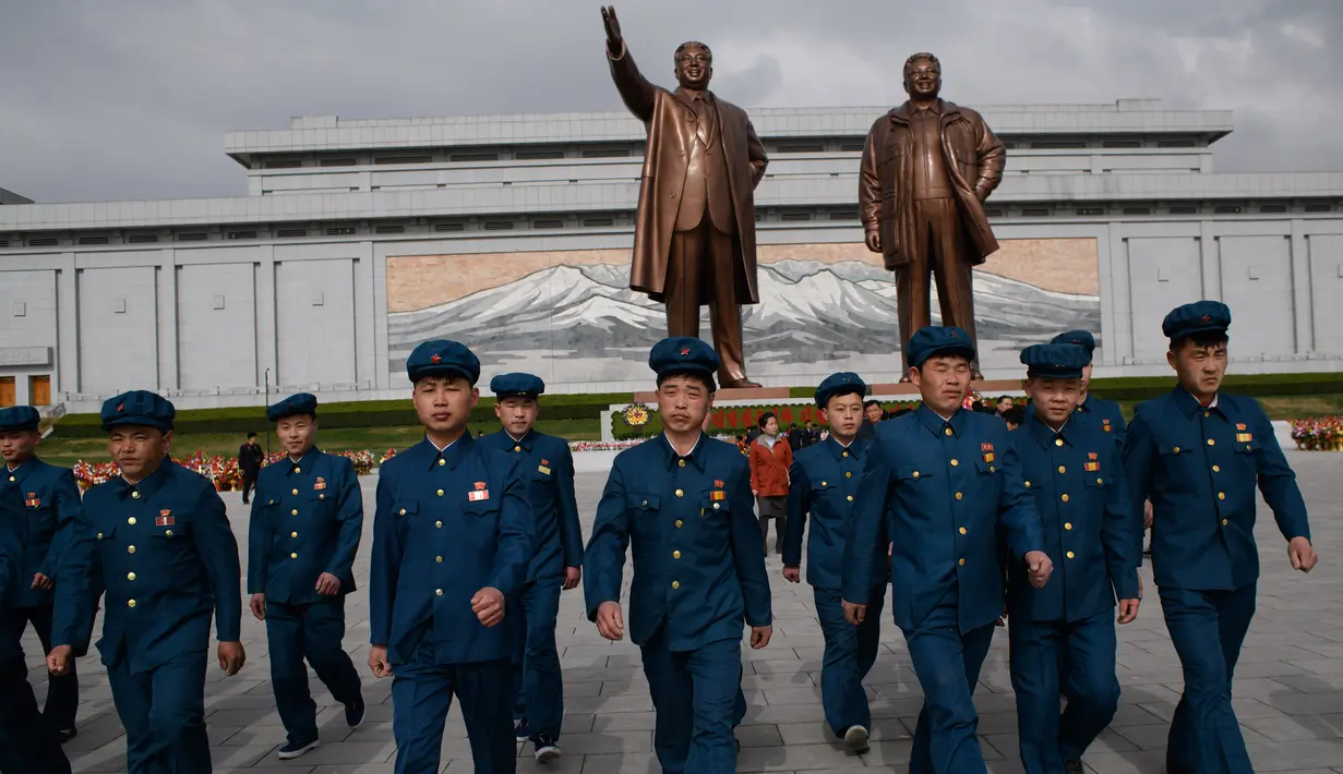 Anggota Liga Pemuda Korea Utara pergi setelah memberi penghormatan kepada patung-patung pemimpin Korea Utara Kim Il Sung dan Kim Jong Il di Pyongyang (15/4). (AFP Photo/Ed Jones)