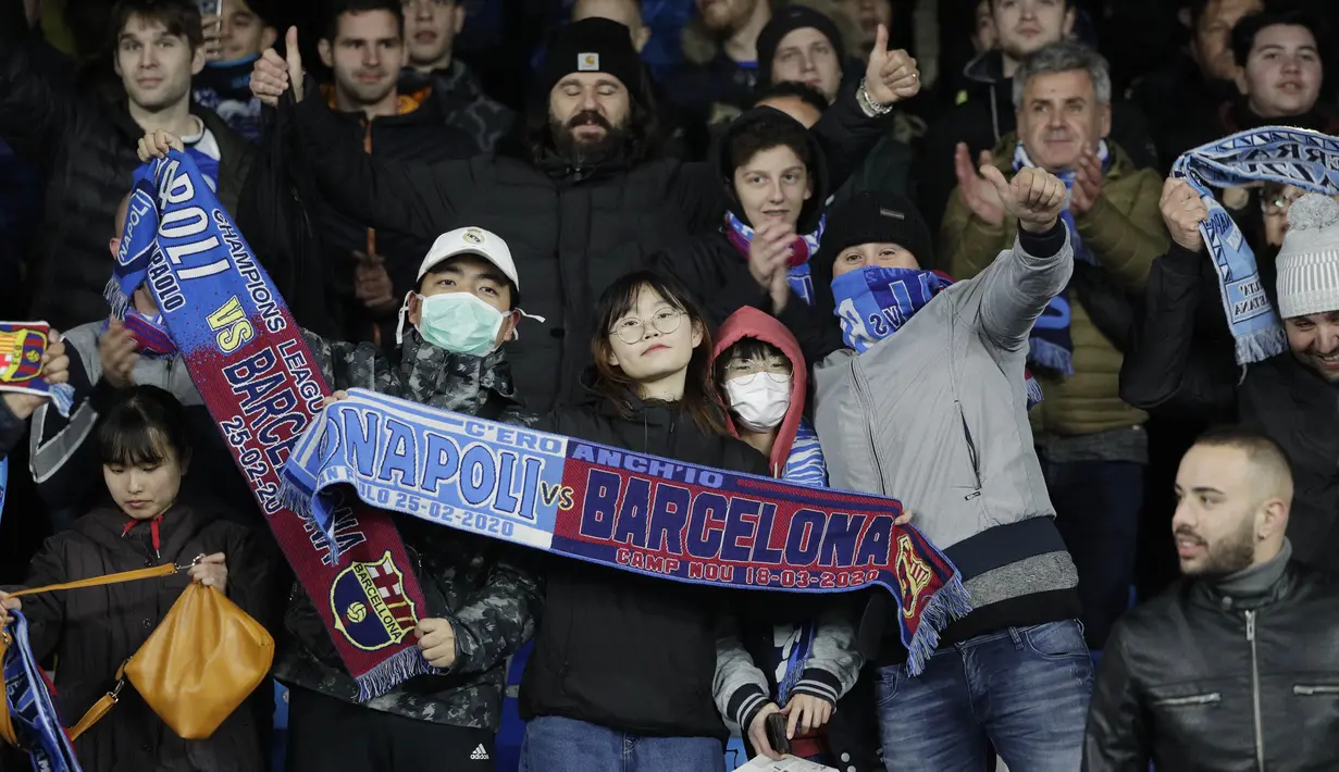 Para suporter mengenakan masker menunggu dimulainya pertandingan antara Napoli dan Barcelona di Stadion San Paolo di Naples, Italia, Selasa, (25/2/2020). Italia melaporkan kenaikan kasus infeksi virus Corona COVID- 91 menjadi lebih 272 kasus. (AP Photo/Andrew Medichini)