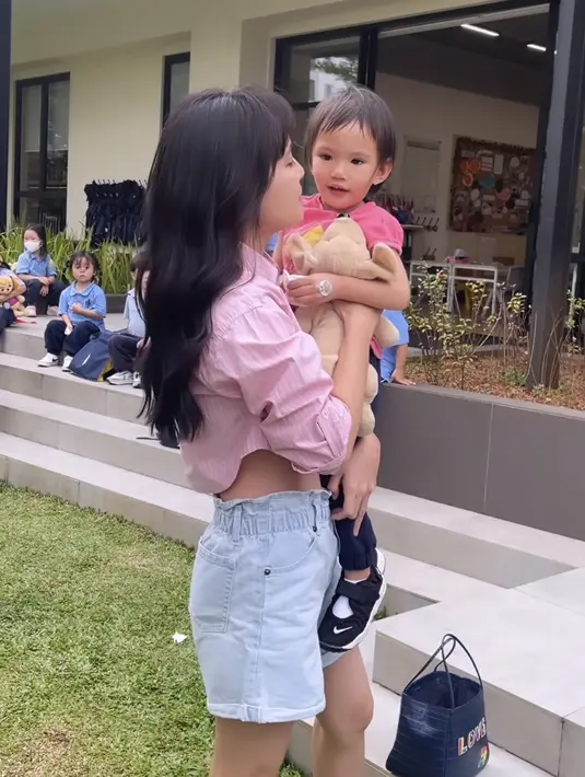 Shandy Aulia juga tampil mengenakan kemeja pink crop top yang dipadukan denim short pants dan flat shoesnya. (@shandyaulia)