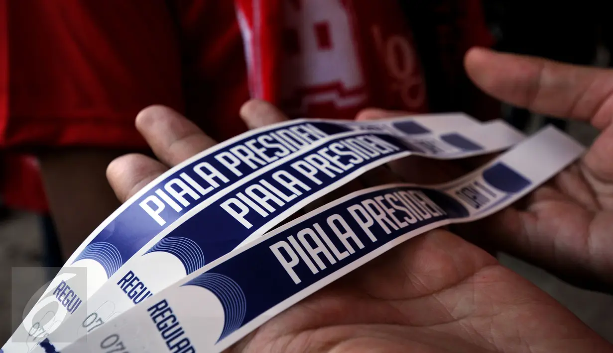 Suporter menunjukkan tiket masuk Stadion I Wayan Dipta, Gianyar, Bali, Minggu (30/8/2015). Jelang pembukaan turnamen Piala Presiden 2015, ribuan suporter menyerbu stadion Dipta, Gianyar, Bali. (Liputan6.com/Helmi Fithriansyah) 