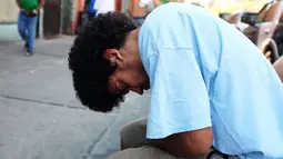 Seorang pria tertidur usai mengisap ganja sintetis atau dikenal dengan K2 di pinggir jalan East Harlem, New York (5/8/2015). Warga AS terutama remajanya tengah kecanduan oleh ganja sintetis atau yang disebut 'Spice'. (AFP PHOTO/SPENCER PLATT)