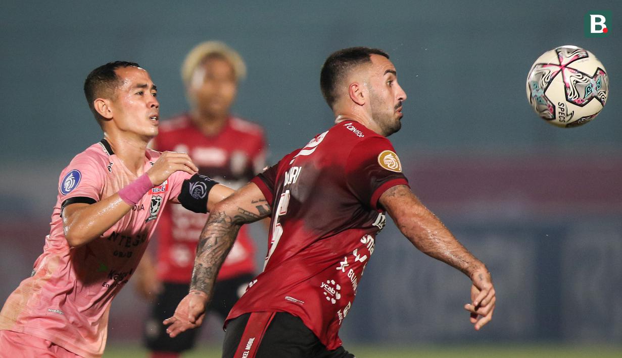 Pemain Bali United, Brwa Hekmat Nouri (kanan) berebut bola dengan pemain Madura United, Slamet Nurcahyo dalam laga pekan ke-16 BRI Liga 1 2021/2022 di Stadion Sultan Agung, Bantul, Kamis (09/12/2021). (Bola.com/Bagaskara Lazuardi)