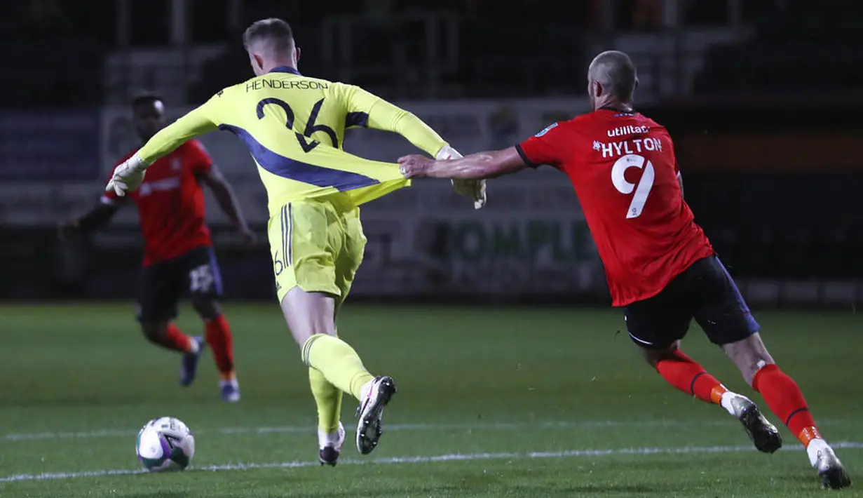 Kiper Manchester United, Dean Henderson, ditarik pemain Luton Town, Danny Hylton, pada Piala Liga Inggris di Stadion Kenilworth Road, Rabu (23/9/2020). Setan Merah menang dengan skor 3-0. (Cath Ivill/Pool via AP)