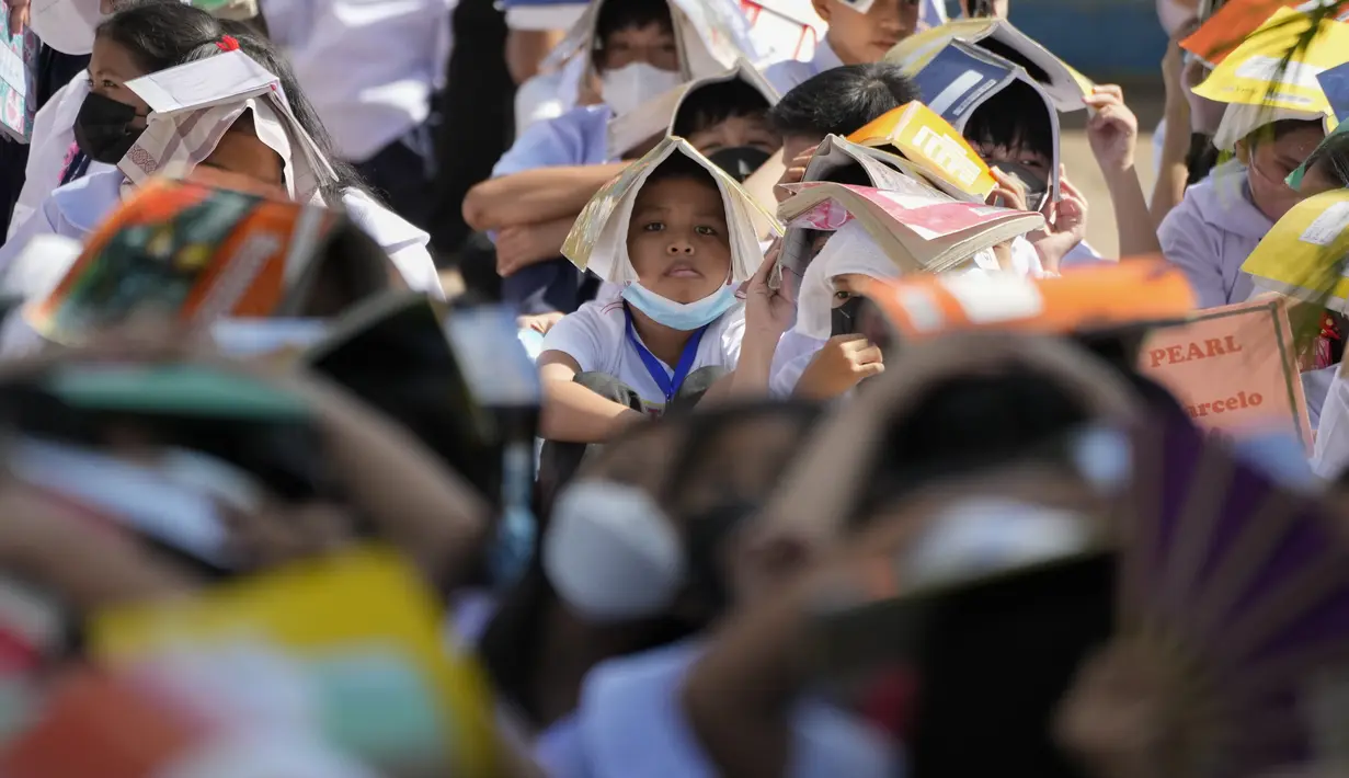 <p>Siswa menempatkan buku di kepala mereka untuk perlindungan selama latihan gempa di sebuah sekolah dasar di Metro Manila, Filipina, Kamis (8/9/2022). Filipina melakukan latihan gempa nasional kuartal ketiga sebagai bagian dari upaya untuk membuat publik mengetahui protokol dan tanggapan selama bencana. (AP Photo/Aaron Favila)</p>