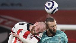 Pemain Liverpool, Nathaniel Phillips, duel udara dengan pemain Sheffield United, Oliver McBurnie, pada laga Liga Inggris di Stadion Bramall Lane, Minggu (28/2/2021). Liverpool menang dengan skor 2-0. (Oli Scarff, Pool via AP)