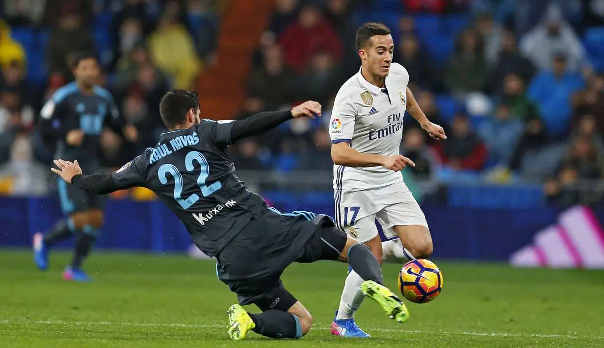 Aksi pemain Real Madrid, Lucas Vazquez (kanan) saat mencoba melewati hadangan pemain Real Sociedad, Raul Navas pada laga La Lga Spanyol di Santiago Bernabeu stadium, Madrid (29/1/2017). Madrid menang 3-0. (AP/Francisco Seco)