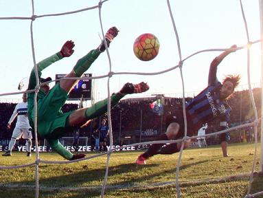 Kiper Inter Milan, Samir Handanovic (kiri)  menghalau bola sepakan pemain Atalanta,  Luca Cigarini pada lanjutan Liga Italia Serie A di Stadion Atleti Azzurri, Bergamo, Sabtu (16/1/2016).  (EPA/Paolo Magni)
