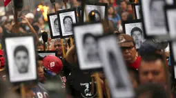 Keluarga dari 43 mahasiswa Meksiko yang menghilang melakukan long march di jalanan Meksiko City, Selasa (26/4). Mereka mendesak pemerintah segera menangani kasus yang sudah 19 bulan berlalu tersebut. (REUTERS/Edgard Garrido)