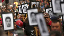 Keluarga dari 43 mahasiswa Meksiko yang menghilang melakukan long march di jalanan Meksiko City, Selasa (26/4). Mereka mendesak pemerintah segera menangani kasus yang sudah 19 bulan berlalu tersebut. (REUTERS/Edgard Garrido)