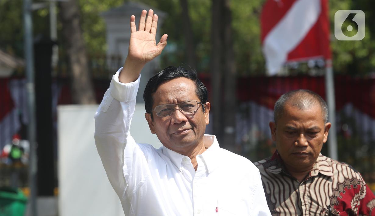 Mantan Ketua Mahkamah Konstitusi Mahfud MD melambaikan tangan saat tiba di kompleks Istana, Jakarta, Senin (21/10/2109). Kedatangan Mahfud MD berlangsung jelang pengumuman menteri Kabinet Kerja Jilid II oleh Presiden Joko Widodo atau Jokowi. (Liputan6.com/Angga Yuniar)
