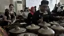 Wisatawan asing berlatih menjadi Nayaga saat lokakarya "Suara Dari Masa Lalu" di Museum Nasional, Jakarta, Minggu (22/12/2019). Lokakarya ini bertujuan mengenalkan sejarah gamelan dan mengajak generasi muda atau milenial mampu melestarikan musik tradisional Indonesia. (merdeka.com/Iqbal S. Nugroho)