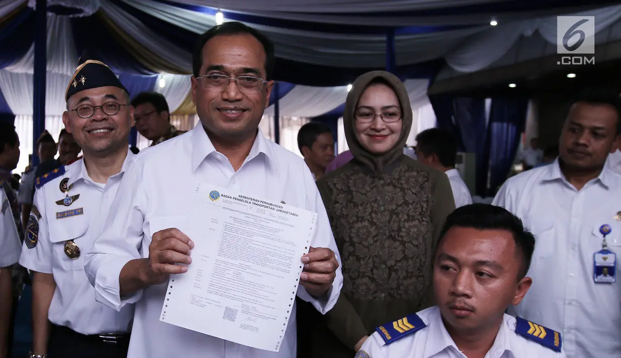 Menhub Budi Karya Sumadi menunjukan berkas terkait perizinan angkutan sewa khusus berbasis daring yang diluncurkan di Jakarta (16/7). Sistem ini juga memudahkan masyarakat untuk mengajukan izin operasional kendaraan. (Liputan6.com/Herman Zakharia)